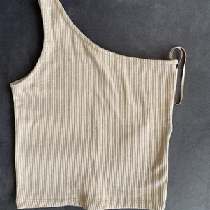 Beige topp från Gina - Ribbat linne med ett band, superfint nu till sommaren. Kommer även sälja denna fast i vit också
