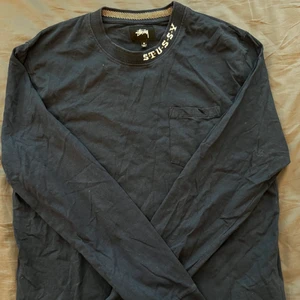 Stussy tröja - Snygg stilren långaramd tröja från stussy i tunnt bomull. Navyblå och ficka fram på vänster bröst. Passar mig som en regular fit, är 183 och väger 78. I priset i går frakten. Skriv om ni har frågor såklart!:) Kram❤️☮️