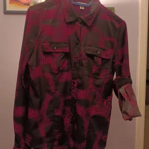 Ny calvin klein dam skjorta  - Längd 60 cm ungefär mörkgrå och cerise rosa figursydd metallknappar ärmar som går att ha uppkavlade med hjälp av en knapp 60 cm längd djur och rökfritt hem finns på eskilsvägen vid Haninge centrum men kan träffas upp i Stockholm området eller skicka på po