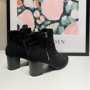 Snygga boots med guldkedja och klack - Säljer dom här snygga bootsen pga. att dom tyvärr är lite för små för mig! Endast använda vid ett tillfälle så skicket är som nya med lappen under skon kvar. Materialet är i mocka. 200 kr plus frakt ❤️