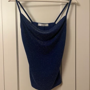 Blå glittrig blus - FINT blå glittrigt linne/blus från sisters point! Den är i storlek Xs men funkar för S också! Använd endast 1 gång💕💕