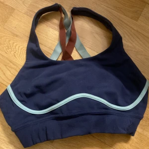 Sportbh - Snygg mörkblå sport bh med kors på ryggen. Använd 2 gånger men passar inte mig tyvärr. Passar S-M 
