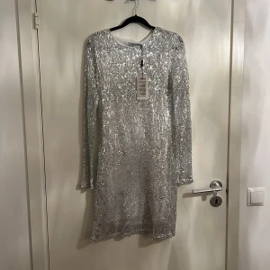 Klänning  - Oanvänd silver glitter klänning med etiketten kvar! Storlek 38 . 