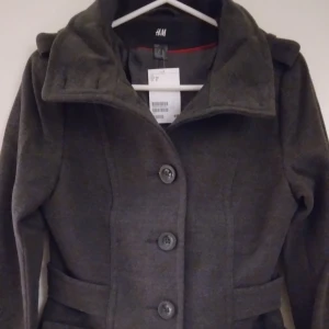 HELT NY & OANVÄND mörkgrå dam höstjacka / skepparkavaj. Strlk 34 / XS-SMALL. - Helt NY och oanvänd snygg och classy mörkgrå höst/vår-jacka i skepparkavaj-stil. Storlek: 34/XS-SMALL. Stängs med knappar och har 2 fickor med lock. Helt felfri/inga defekter. Lapparna/tags sitter kvar sedan inköpet.