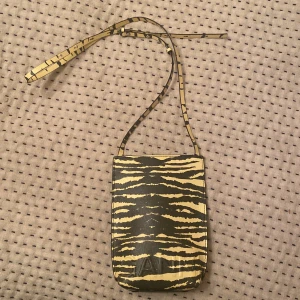 GANNI väska  - Oanvänd! Nyskick Ganni väska. Cross shoulder. Ställbar axelrem. Lusgul / gråbrunt zebra mönster