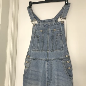 Blåa jeans hängselbyxor - Hängselbyxorna är lagom visa i benen. Kom priv om du vill ha bild på baksidan av hängselbyxorna :)