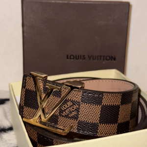 LOUISE VUTTION BELTE - Guldig lv belte. Helt ny. Oanvänt.