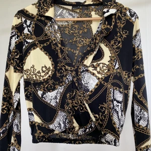 Low-Cut Top - Somrig top med jättenfint mönster. Toppen är väldigt urringad och passar perfekt till en elegant eller somrig outfit. Använt 1 gång, väldigt god skick. 