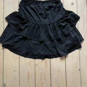 Svart volangkjol  - Svart volangkjol. Vet inte storleken eftersom jag klipppte bort lappen men extremt stretchig så passar xs/s/m/l/xl. Kan även användas som en topp.