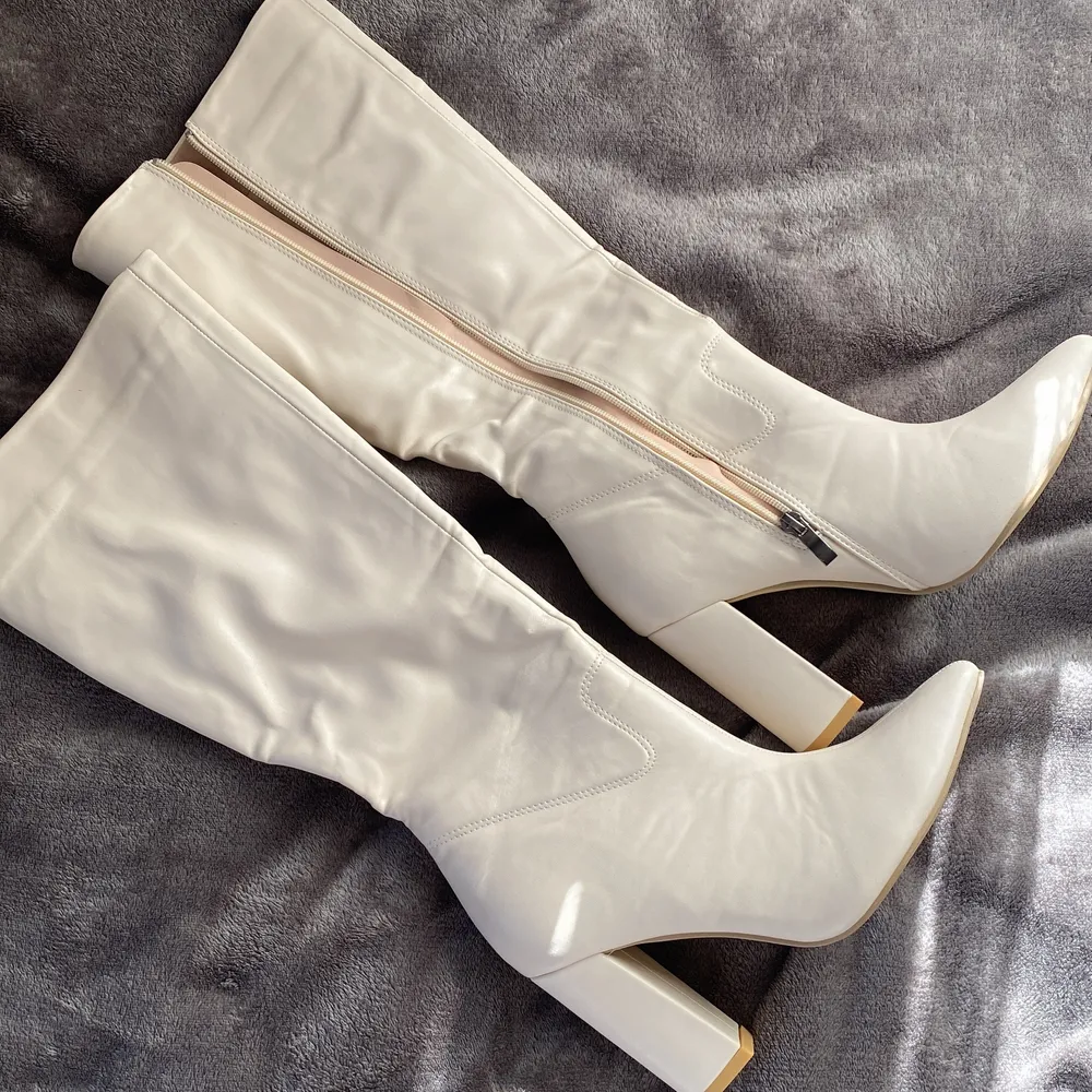 Oanvänd vit boots med blixtlås vid sidorna av skorna (se bild 3). Den är i storlek 38(:. Skor.