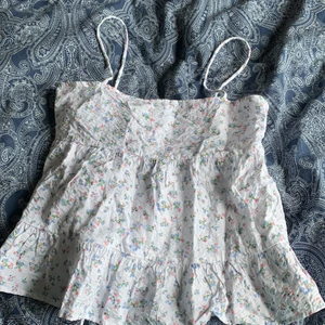Sommartopp från ginatrocot i storlek S - Denna sommartopp är en fin vit färg med pastell Blom mönster, den är puffig för den som gillar! I storlek S