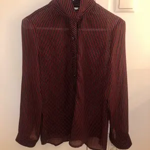 svart och röd randig tröja. den är lite genomskinlig så bäst att ha ngt under. vet ej vart köpt och har aldrig använt