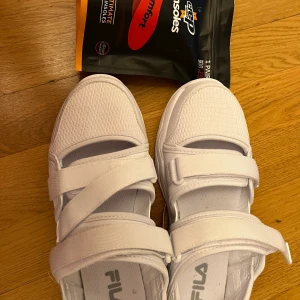 Fila sommarskor - Helt nya sommarskor fila skor. Dom är vita. Oanvända. Dom passar inte mig. Var för stora på mig. Extra sulor i ett Packtet.   Storlek 38 skor.   Säljer skor för 280 kr plus sulorna för 80 kr.   Mitt pris är 280 kr plus 80 kr   ENDAST FRAKT. Endast Swish  