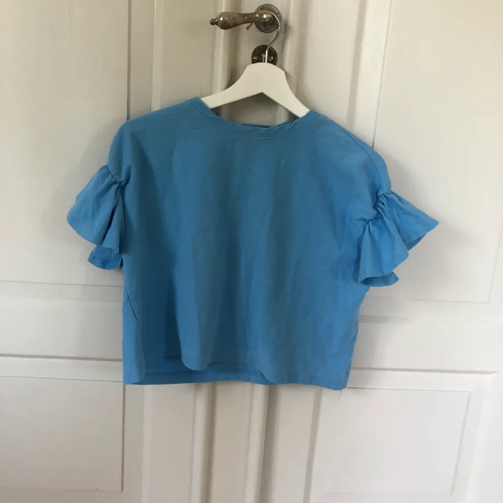 En blå volangärmad tröja! I storlek 36 men passar mindre med! Den är i från H&M! De kostar 60kr och frakten är 39kr. 60+39=99kr. T-shirts.
