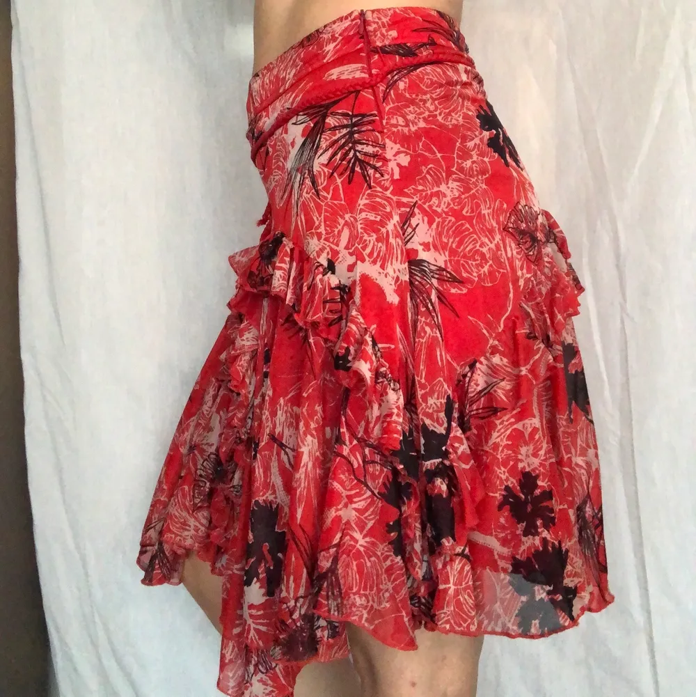 Röd kjol med volanger, knytbälte och dragkjedja på sidan. I superfint skick, storlek 38 och från not the same NTS. . Kjolar.