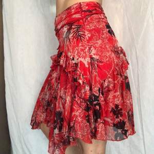 Röd kjol med volanger, knytbälte och dragkjedja på sidan. I superfint skick, storlek 38 och från not the same NTS. 