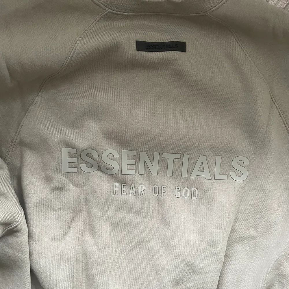 En Essentials sweatshirt storlek S, Essentials tryck på ryggen. Använd 3-5 gånger. Den är i en brun grå färg. . Hoodies.
