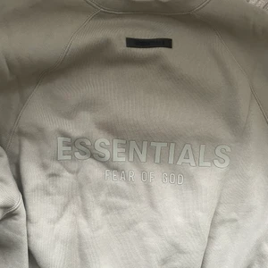 Essentials Sweatshirt  - En Essentials sweatshirt storlek S, Essentials tryck på ryggen. Använd 3-5 gånger. Den är i en brun grå färg. 