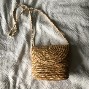 Stråväsks liten - Strå-axelremsväska från hm! Sällan använd, gott skick. Mått väska: ca 20x23 Mått rem: ca 110 (cm)