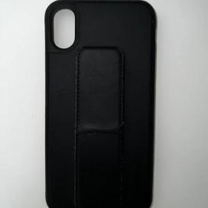 iPhone XS skal - Väldigt fint skal från okänt märke passande till iPhone XS. Det är i använt men fint skick. Den har även ett inbyggt stöd för att lättare kunna hålla i handen eller sätta ner på t.ex ett bord. Köpare står för frakten!