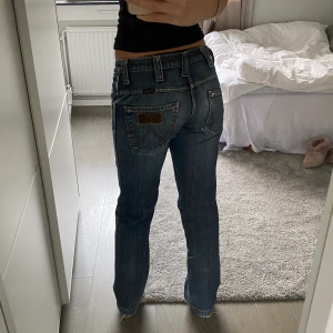 Wrangler lågmidjade jeans - Lågmidjade jeans från wrangler i snygg blå tvätt. Köpta second hand men endast använda fåtal gånger av mig. Lite slitningar (bild 3) men inget märkbart 💓Midjetmåttet är ca 80cm