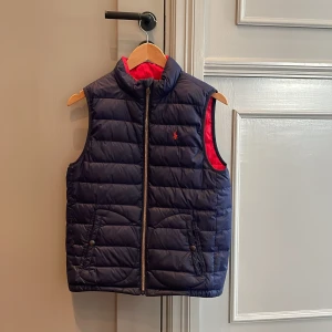 Ralph lauren väst storlek 14-16 år  - Nu säljer jag min Ralph lauren väst på grund av att den är för liten och bara hänger i garderoben.  Storlek 14-16 år( liten i storleken) Går att ha den i både blå och röd( vändbar) 
