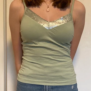 Pastel grönt linne med paljetter  - Pastel grönt line med tajt pass form och paljetter , åtdragsbara axelband!