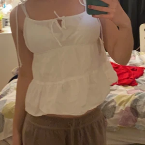 Vit topp - Säljer min gulliga vita topp från hm❤️ Köpte för 149 och säljer för 80 väldigt fin att ha på sommaren. Man kan justera snörena. Storlek 36 och använt få gånger. Kan mötas och frakta!