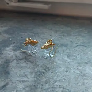 Små glasörhängen med guldfärgade detaljer, i motiv av renar