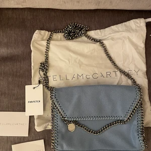 Blå ny Stella Mccartney väska falabella  - Säljer min helt oanvända Stella mccartney falabella väska, både tagen är kvar och plasten för knäppet på insidan. Inköpt på farfetch för 6560kr, kvitto finns! Dustbag, äkthetsbevis och allt som man får till kommer med! Säljaren står för frakt ❤️ pris kan diskuteras vid snabb affär