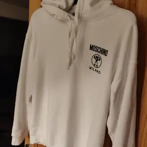 Vit Moschino hoodie storlek L. Nypris 3500. Kvitto finns. Skick 9/10 knappt använd. Priset är inte hugget i sten.
