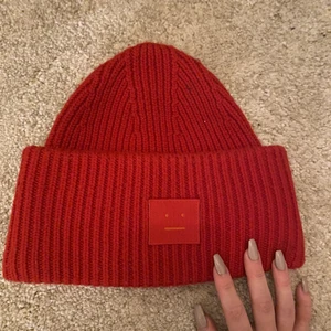 Klassisk acne mössa - Röd acnemössa. Perfekt till jul! Lite lite nopprig vit toppen annars som ny