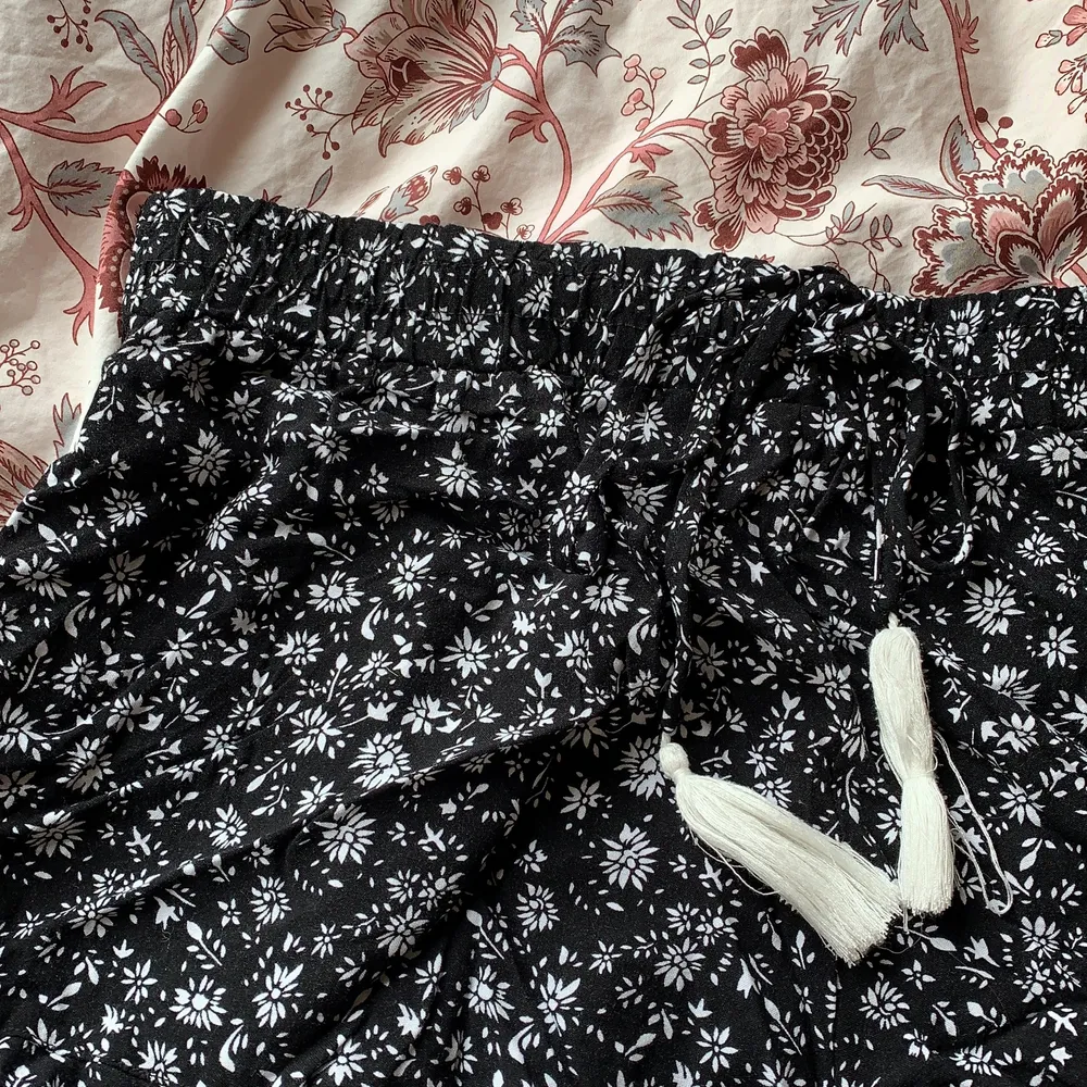 Svarta shorts med vita blommor. Lösa och sköna. Fint skick!. Shorts.