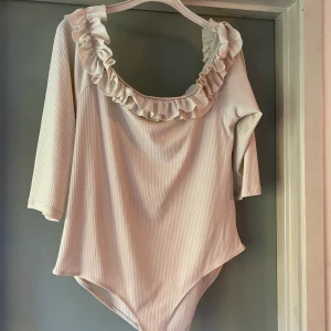 Vit singoallabody - Vit singoallabody köpt från Asos, med volang upptill, använd en gång, väldigt fint skick. 