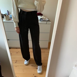 Randiga kostymbyxor från NA-KD! - Säljer dessa svarta kostymbyxor med vita, smala ränder på från NA-KD. Vida och raka i passformen, storlek 36. Använt ca 3 gånger så de är i bra skick! Säljer pga att de inte kommer till användning. Startar budgivning vid många intresserade. Hör av er vid intresse!