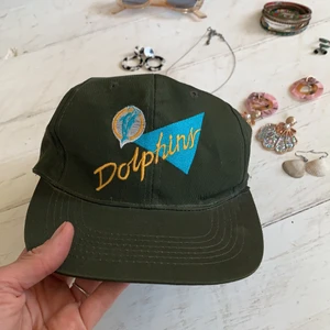 Vintage Dolphins keps - Fantastisk vintage 80s/90s Dolphins keps. Storlek 58 cm. Bottenfärg olivgrön. Mkt nära oanvänt skick!