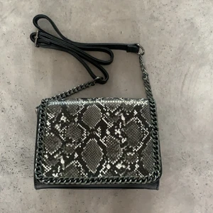 Väska, ormskinn med kedja  - Säljer denna väska. Oklart varifrån jag har köpt den, men den är som ny. Använt den max 2ggr. ⚡️Fraktkostnad kan tillkomma!