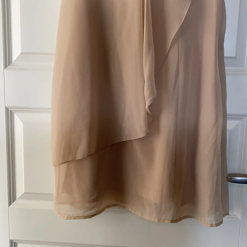 En ljus beige klänning stl38. Knappt använd. Tunt fint tyg 100% polyester tvättas i 30 grader.  Dragkedja i sidan.. Klänningar.
