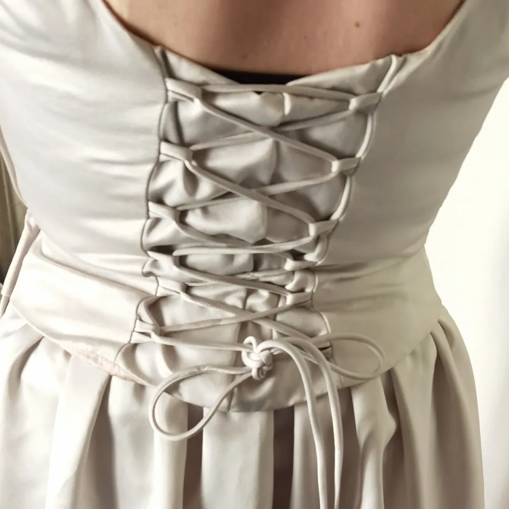 Säljer denna Silvergrå klänning som endast är använd 1 gång på väninnans bröllop, det är först till köp som gäller och priset är diskuterbart.   Lätt och elegant, faller snyggt. Längden på klänningen från axlarna är 137 cm, från dragkedjan är den 93 cm.  Drakedja i sidan och korsett snörningen går att reglera. Finns även en snygg cape som följer med, den är längre på sidorna och kortare i bak, knäpps i halsen.  Finns i Kallebäck eller skickas om köpare betalar spårbar frakt på 99 kronor.. Klänningar.