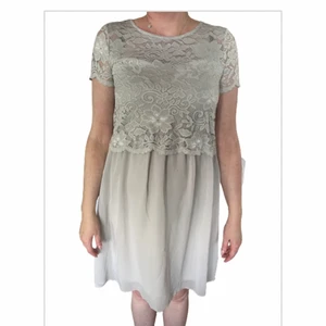 Klänning - Ljusgrå klänning från Happy Holly med ovandel i spets. Stl 40/42. Knälång. Aldrig använd. Skriv till mig om du är intresserad, pris kan diskuteras. Köparen står för frakten.