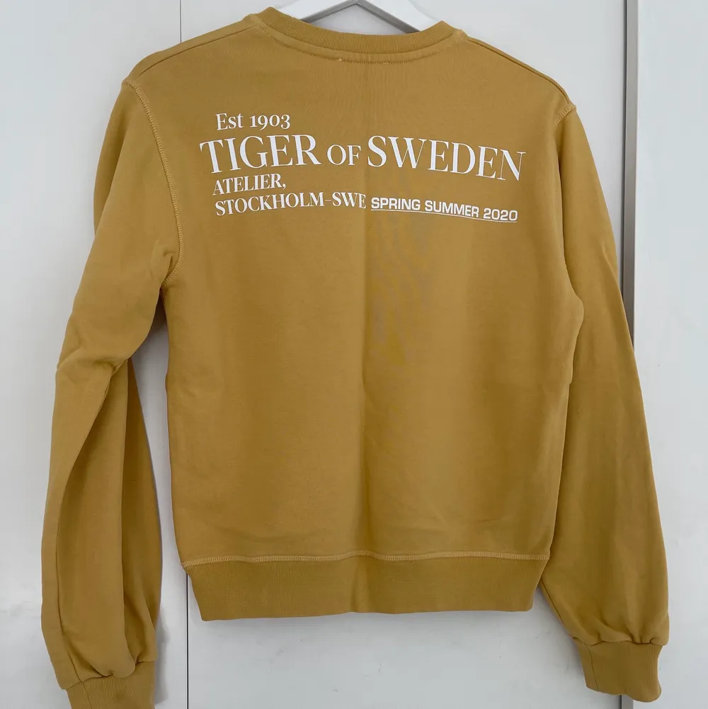 En gul tröja ifrån tiger of Sweden i nyskick. Med tryck på ryggen.. Tröjor & Koftor.
