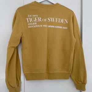 En gul tröja ifrån tiger of Sweden i nyskick. Med tryck på ryggen.