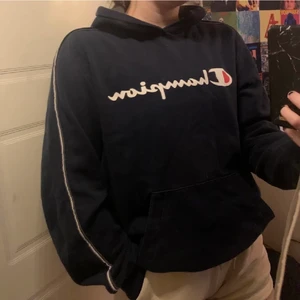 Marinblå Champion Hoddie - Köptes 2020 på secondhand butik. Kort i armarna. Utöver att Snöret är borta så är den hel och fin. Kan mötas upp, annars står köpare för frakt.