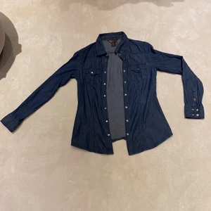 Denim blå skjorta! - En denim blå randig skjorta med silvriga knappar. Använd ett par gånger. 