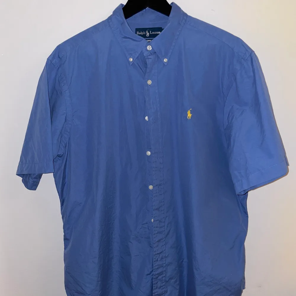 Blå Ralph Lauren skjorta, as snygg att använda som vanlig skjorta eller typ kofta över ett linne. Har en annan liknande skjorta så tänkte sälja av denna då ja ba använt den typ en gång, storlek XL . Skjortor.