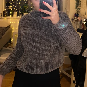 Stickad tröja - Varm stickad tröja i mörkgrå, krage och croppad men går över magen. 