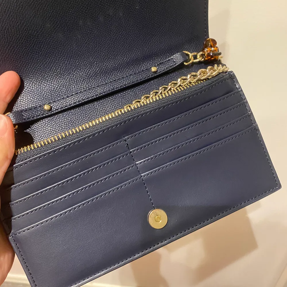 Använt fåtal gånger. Bra skick. Navy blå färg. Märket är guld men med lite repor(därav priset). Laukut & Käsilaukut.