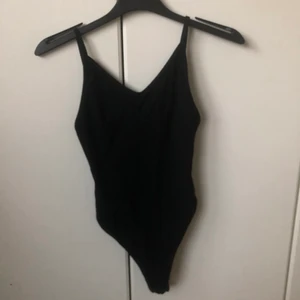 Bodysuit - Svart bodysuit, väldigt töjbar, buren en gång, jätte fin och passar perfekt för en utekväll kanske under sommaren då det är väldigt öppet i ryggen