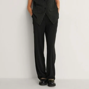 NAKD recycled byxor - Säljer dessa kritstrecksrandiga byxorna från NA-KD. De är uppsydda för att passa mig som är 1,70 cm.