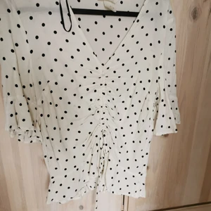 Prickig blus med dragsko strl 36 - Prickig blus från h&m med dragsko och volangär. Storlek 36. Fint använt skick.                         Köparen står för eventuell frakt, skickar med billigaste alternativet eller annat enligt önskemål ☺️